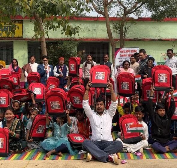Distributing school bags to children